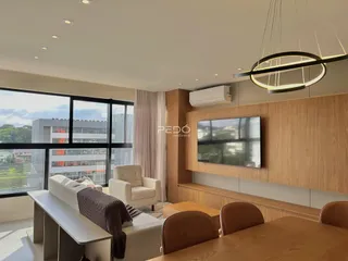 Sala de estar moderna com grandes janelas e painéis de madeira.