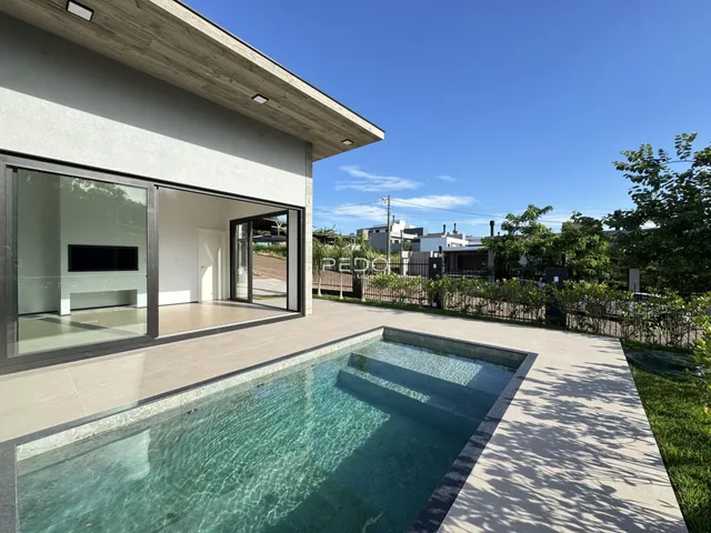 Fachada de casa com piscina e área externa.
