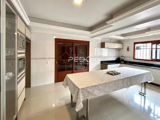 Interior de uma sala de jantar com cozinha moderna em um imóvel no Brasil.