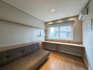 Sala de estar com sofá e piso de madeira clara.