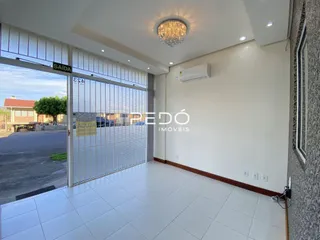 Interior de uma sala com piso de cerâmica e porta de vidro.