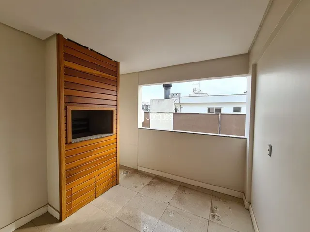 Vista interna de uma sala com painel de madeira e piso claro.