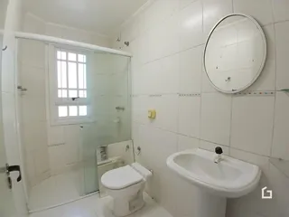 Foto de um banheiro interno com azulejos brancos e box de vidro.