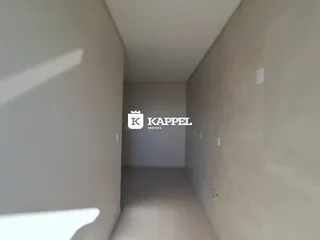 Corredor interno de um imóvel com paredes claras e piso liso.