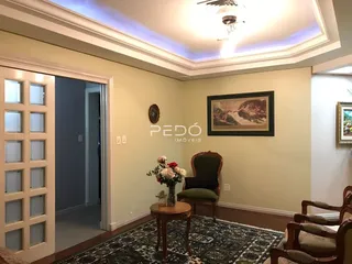 Interior de uma sala com decoração clássica e pintura na parede.