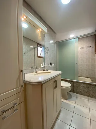 Foto de um banheiro com bancada e box de chuveiro em um imóvel.