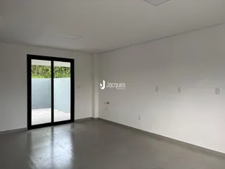 Sala de estar com porta de vidro que dá acesso ao exterior.