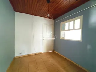 Interior de um cômodo com piso de cerâmica e teto de madeira.