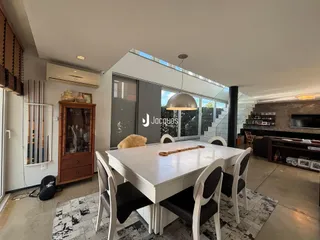 Vista de uma sala de jantar com mesa branca e cadeiras em um imóvel em Lajeado.