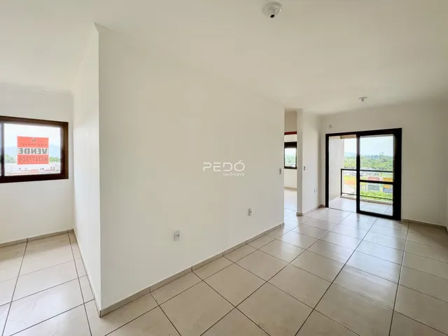 Interior de um corredor com piso de cerâmica e paredes brancas.