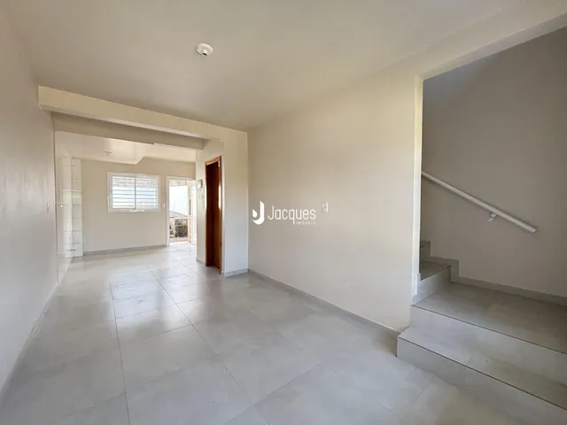 Hall de entrada com piso de cerâmica e paredes brancas.