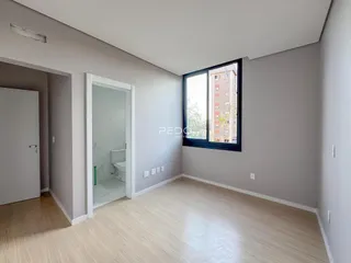 Ambiente interno de um apartamento com piso de madeira clara e paredes cinzas.