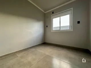 Foto de um cômodo interno com paredes brancas e piso de cerâmica.