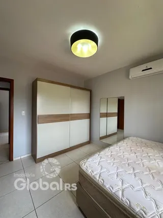 Quarto com cama e guarda-roupa de madeira em um imóvel.