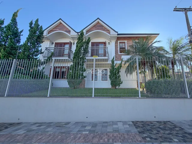 Fachada de uma residência em Lajeado, Brasil, com cerca e vegetação ao redor.