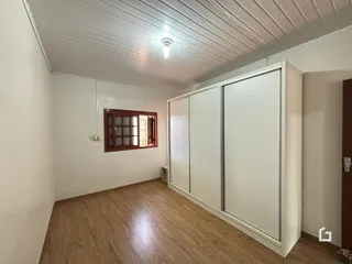 Foto de uma sala com piso de madeira e armário embutido.