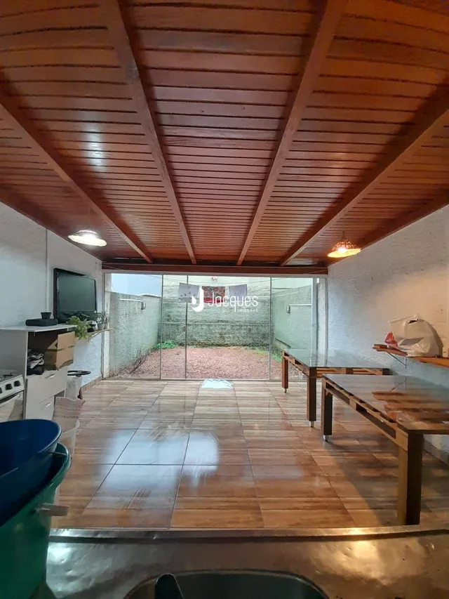 Interior com teto de madeira e piso de cerâmica com acesso a uma área externa.