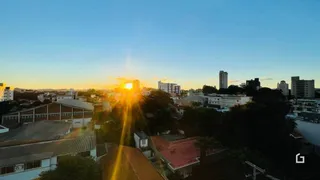 Vista panorâmica de telhados residenciais ao pôr do sol em Lajeado.
