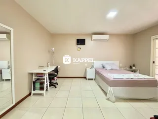 Este é um quarto com cama e uma escrivaninha em um imóvel.