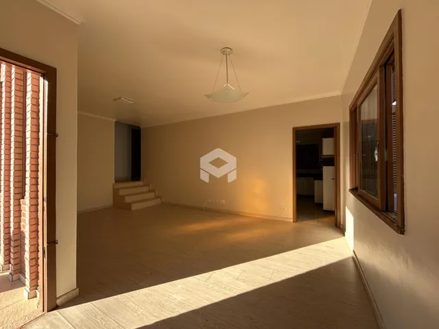 Sala de estar com piso de madeira clara e luz natural entrando pela janela.