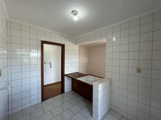 Hall de entrada com piso de cerâmica e paredes brancas.