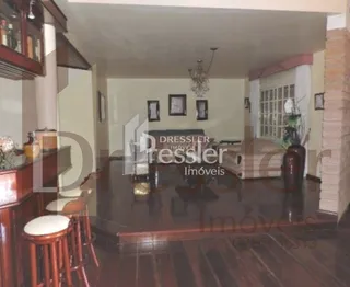 Sala de estar com piso de madeira escura e móveis de madeira.