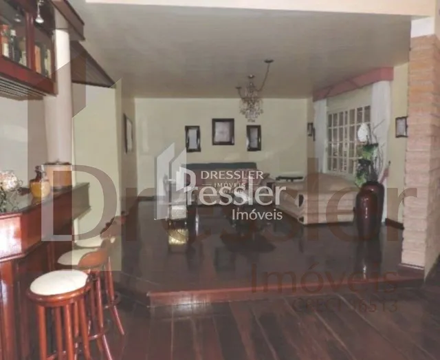 Sala de estar com piso de madeira escura e móveis de madeira.