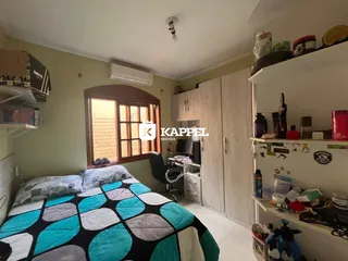 Quarto com cama e janela de madeira em um apartamento.