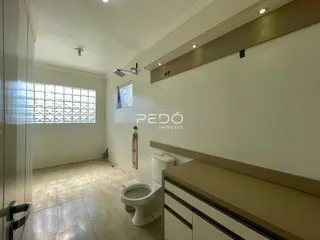 Hall de entrada com piso claro e azulejos na residência.