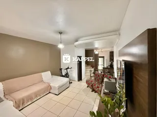 Sala de estar com sofá claro e piso de cerâmica em um imóvel em Lajeado.