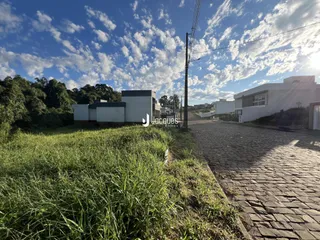 Vista externa de uma propriedade em Lajeado, Brasil, com gramado alto e pátio pavimentado.