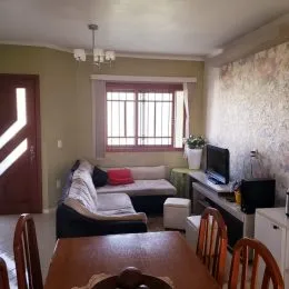 Foto interna de uma sala com sofá e janela em um imóvel.