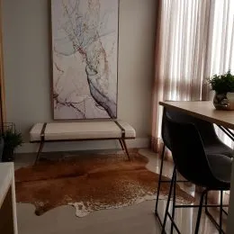 Foto de uma sala com grande janela e cortinas claras.