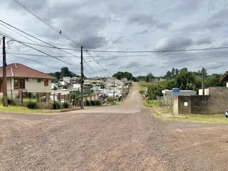 Vista de uma rua de terra em uma área residencial em Lajeado.