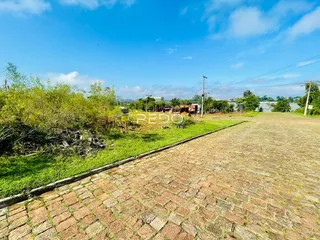 Vista externa de um terreno com gramado e caminho de tijolos em Lajeado.