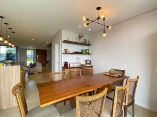 Sala de jantar com mesa de madeira e cadeiras de vime.