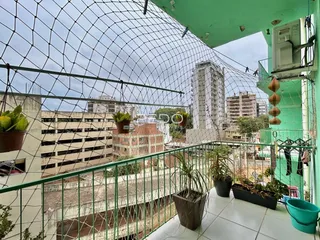 A vista da varanda mostra edifícios ao fundo da cidade.