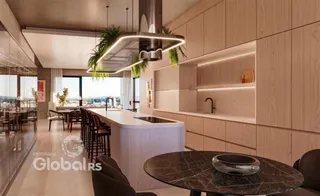Cozinha moderna com ilha e armários de madeira clara em um ambiente de sala de jantar.