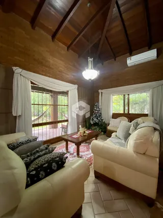 Sala de estar com pé direito alto e decoração rústica de madeira.