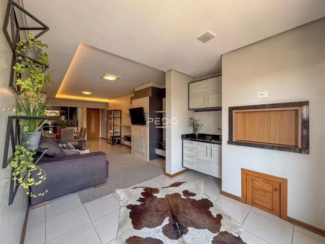 Sala de estar com ambiente integrado de sala de jantar e cozinha.