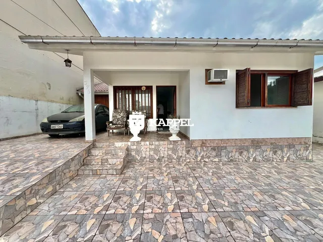 Foto da fachada de uma residência em Lajeado, Brasil, mostrando a entrada coberta e o piso externo.