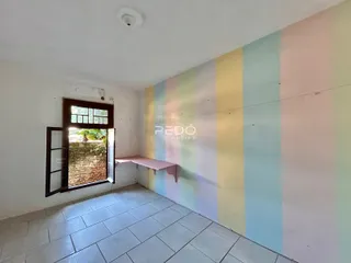 Ambiente interno com piso de cerâmica e parede decorada em tons pastéis.