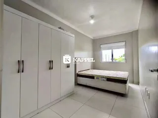 Foto de um quarto com armários brancos e uma cama.