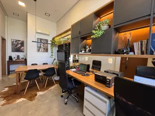 Ambiente de escritório com mesa de madeira e estantes em um imóvel no Brasil.