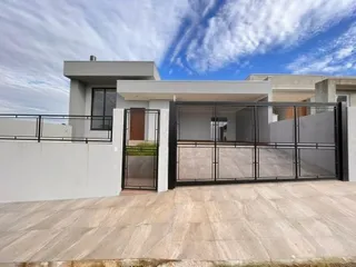 Fachada moderna de uma residência com deck de madeira e grade de metal preta.