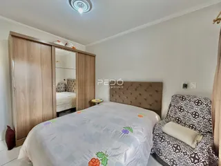 Quarto com armários de madeira e cama decorada.