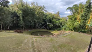 Vista externa de um terreno com gramado e um lago.