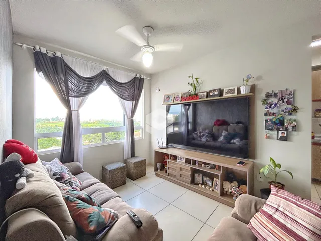 Sala de estar com grande janela e cortinas em um imóvel no Brasil.