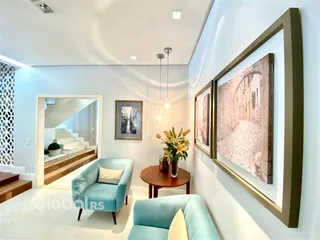 Sala de estar com dois sofás azuis e paredes brancas em um imóvel no Brasil.