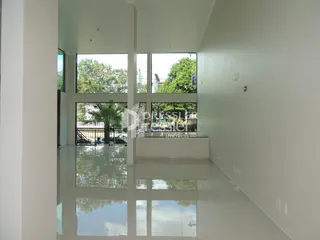 Vista interna de um ambiente com piso reflexivo e grandes janelas.